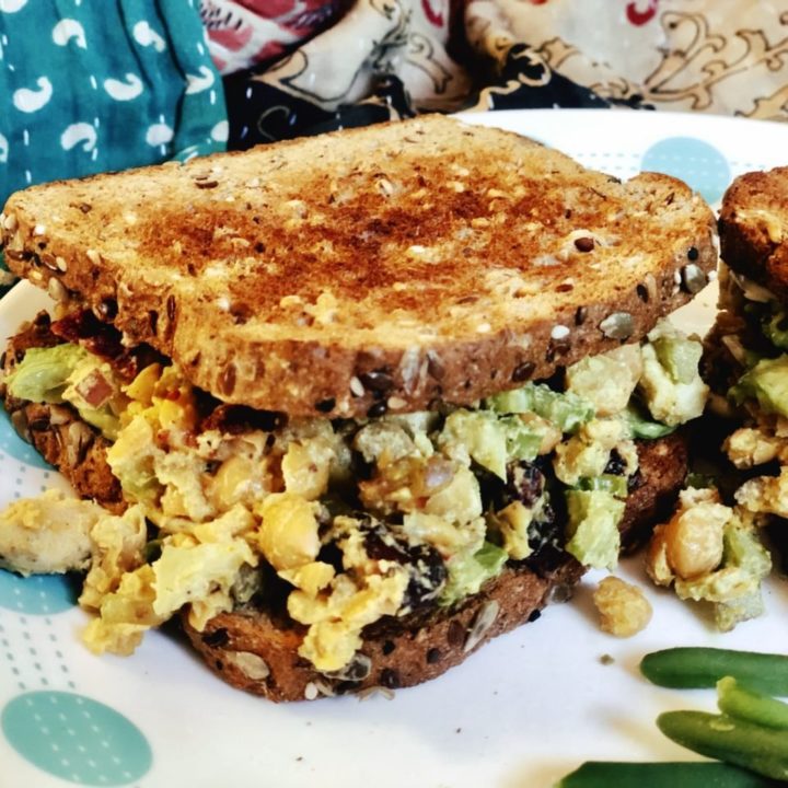 vegan curried chickpea salad sandwich on a plate.