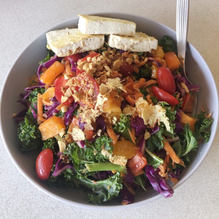 asian style cabbage kale salad in a bowl with tofu.