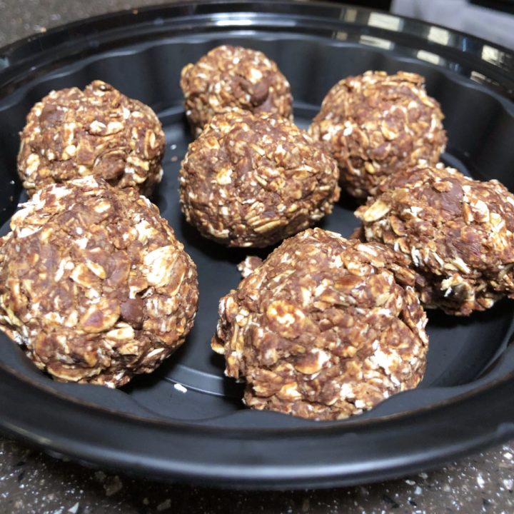 a black bowl filled with chocolate almond balls.