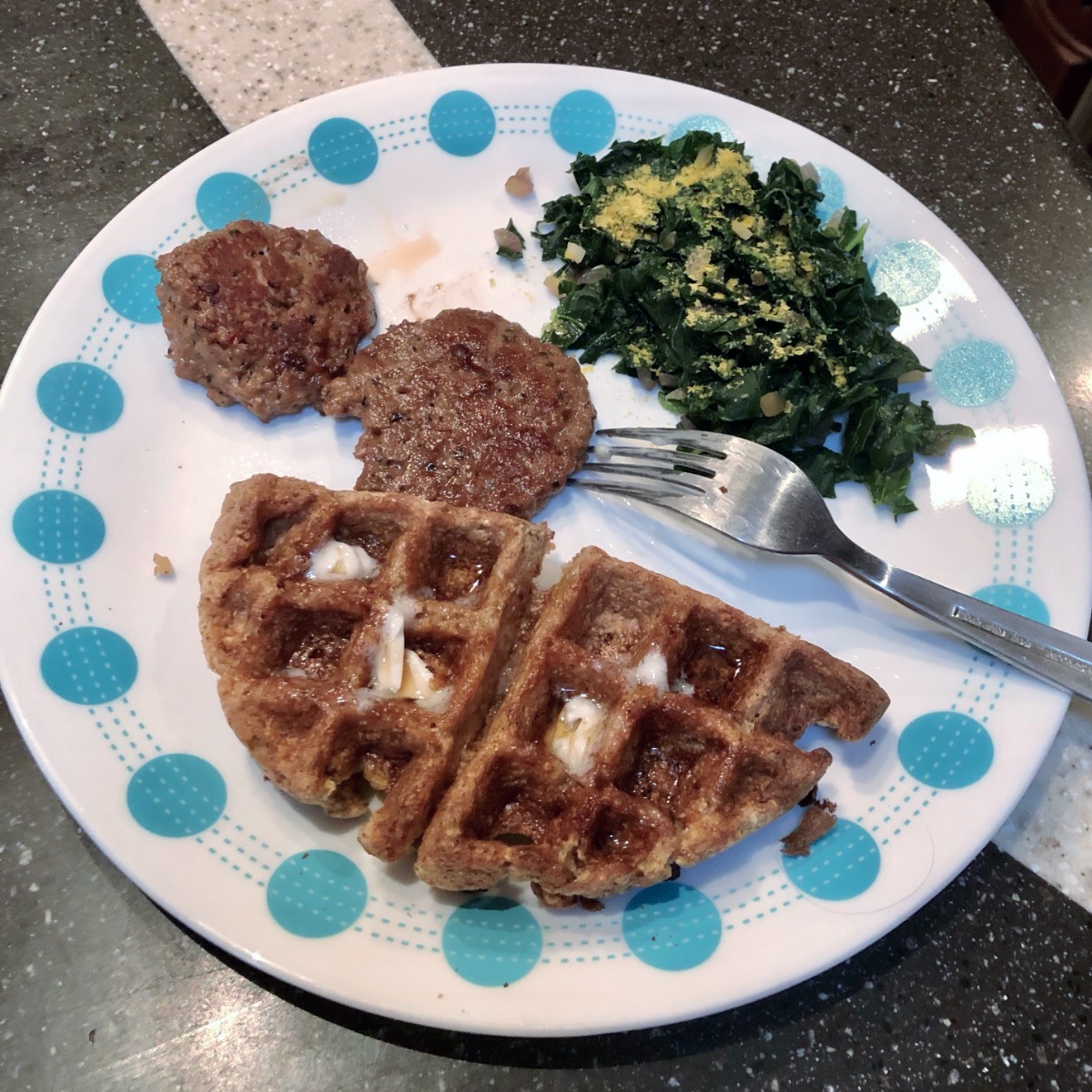 vegan belgian waffle, impossible sausage and kale on a plate.