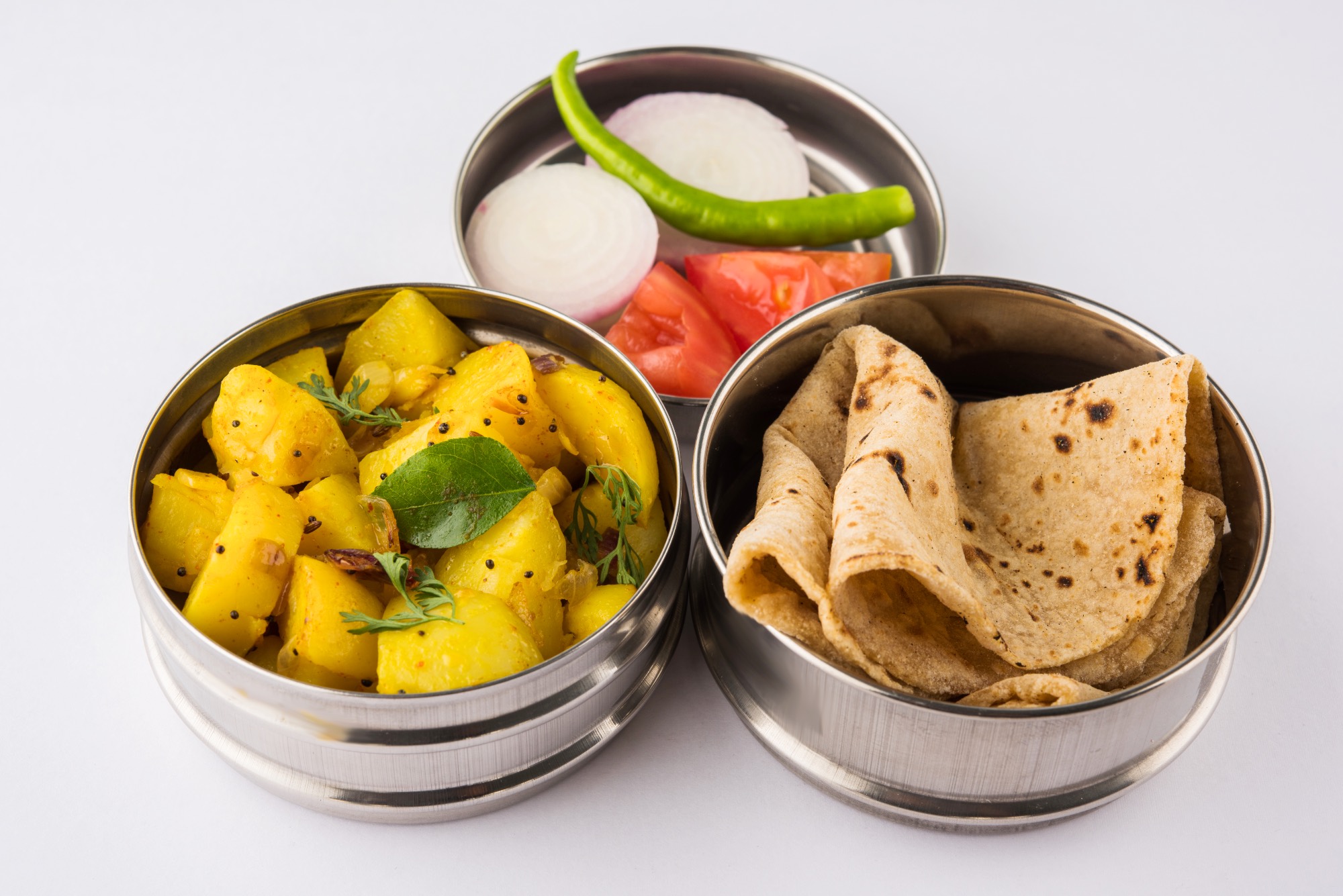 three round stainless steel containers containing food.