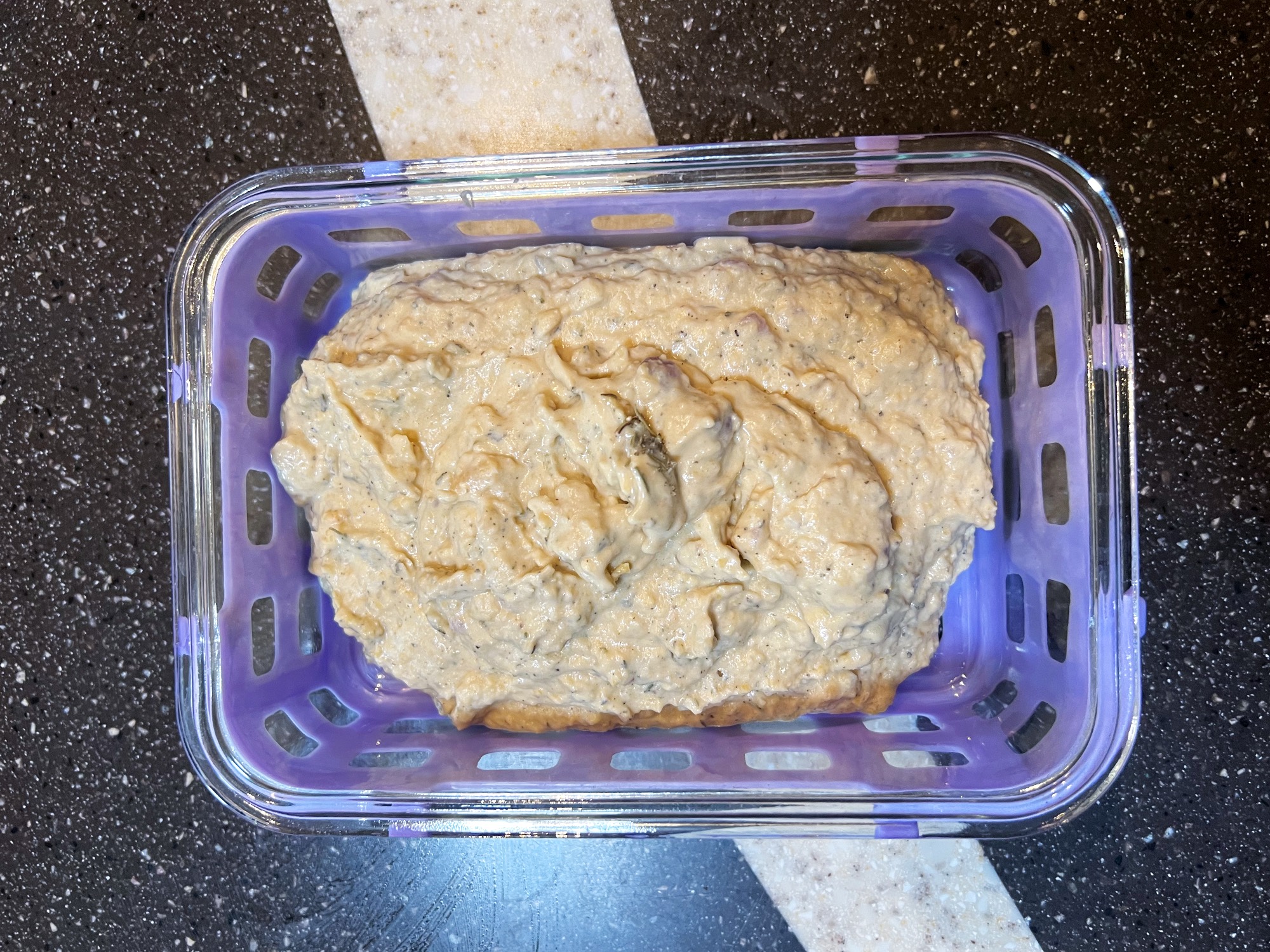 a glass storage container filled with hummus that tastes like thanksgiving.