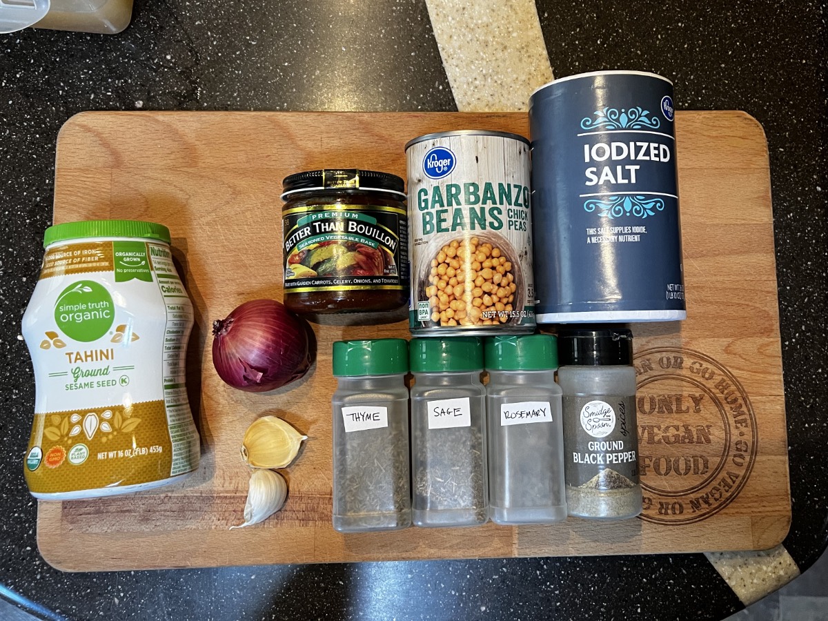 all of the ingredients needed for thanksgiving hummus on a wooden cutting board.