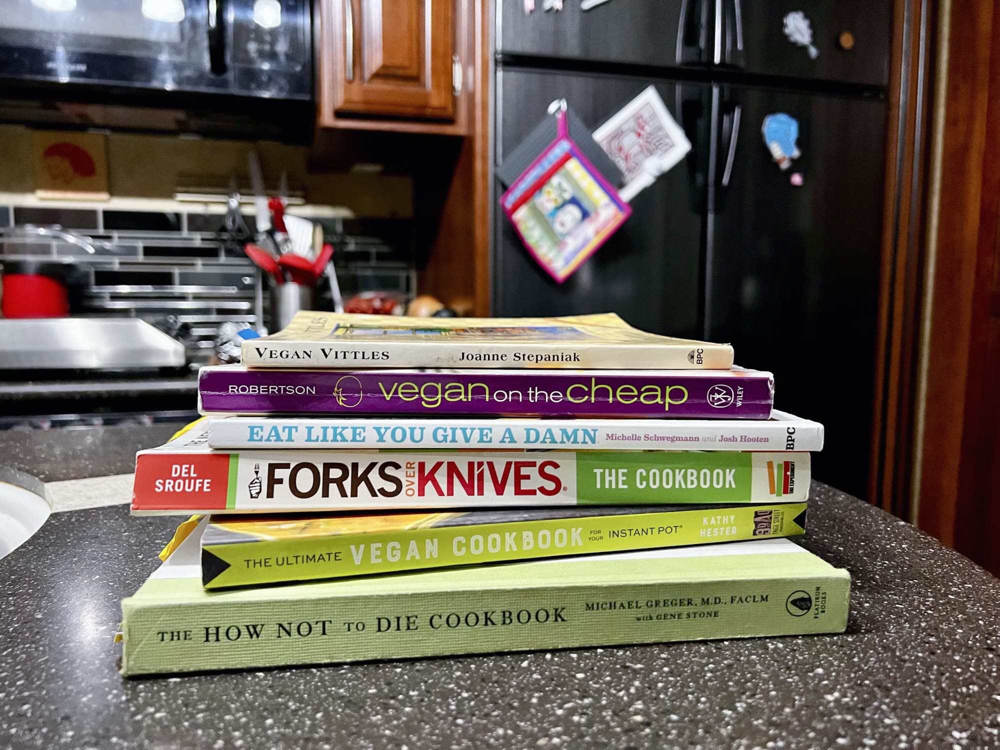 stack of vegan cookbooks on a counter.