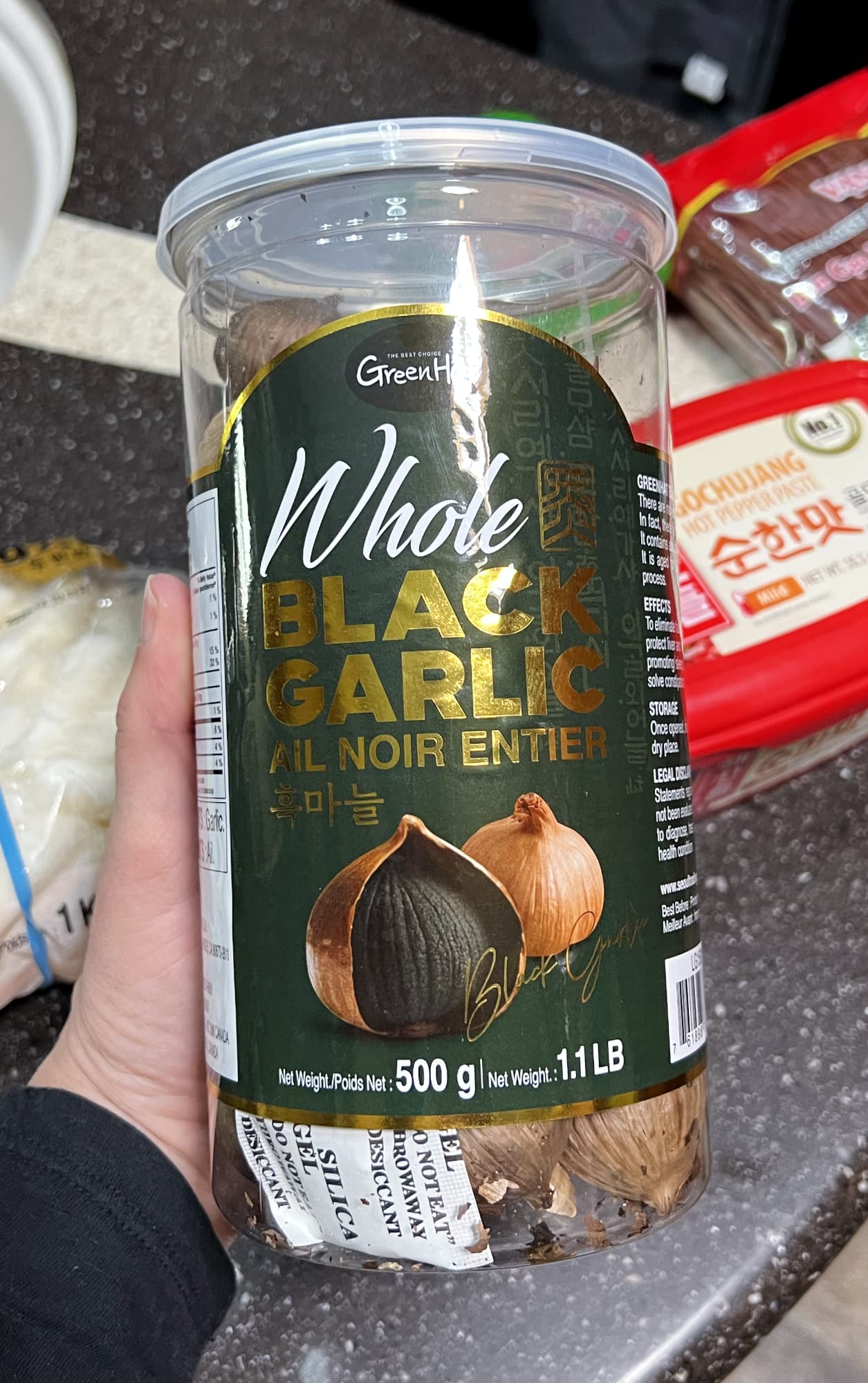 container of whole black garlic.