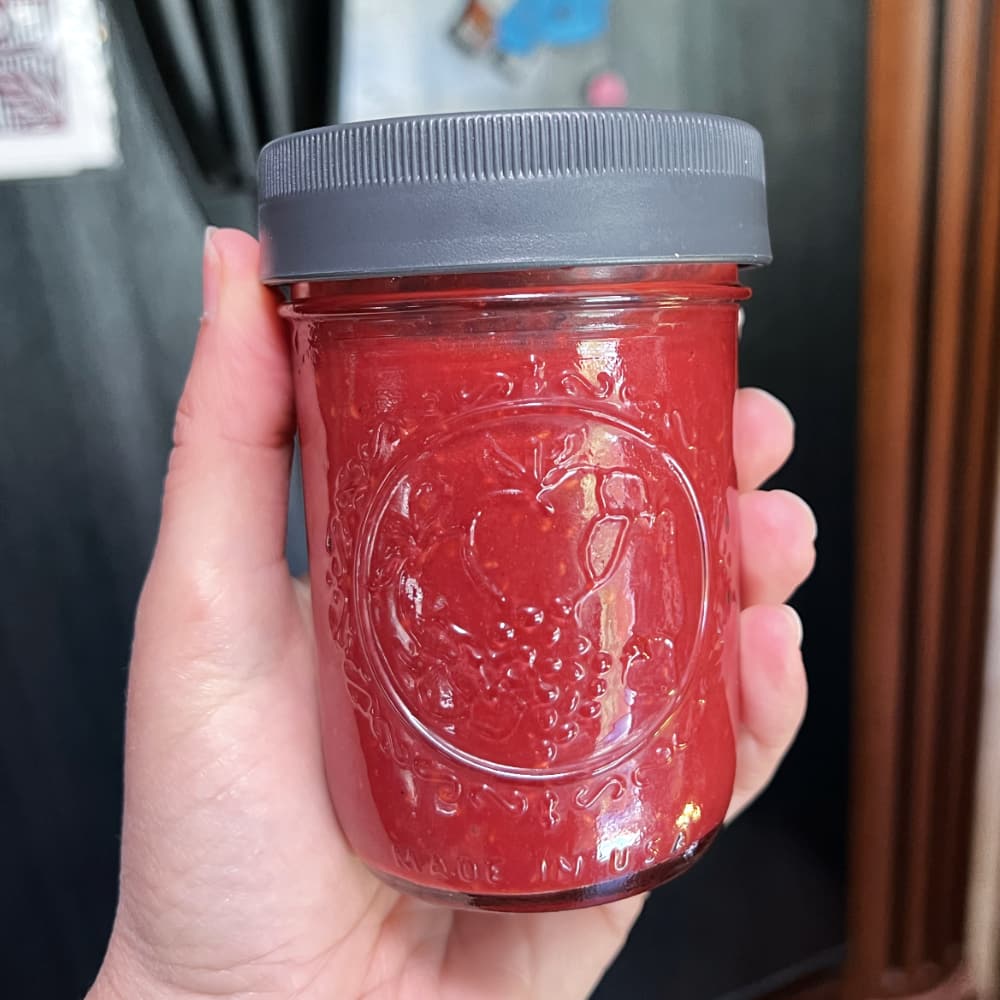 a mason jar full of raspberry balsamic dressing.